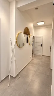 Korytarz salonu Glamour z okrągłymi lustrami w złotych ramach.