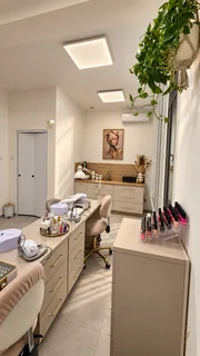 Widok wzdłuż stanowisk manicure w salonie Glamour.