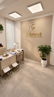 Złoty znak Glamour Urszula Zakrzewska na ścianie salonu.